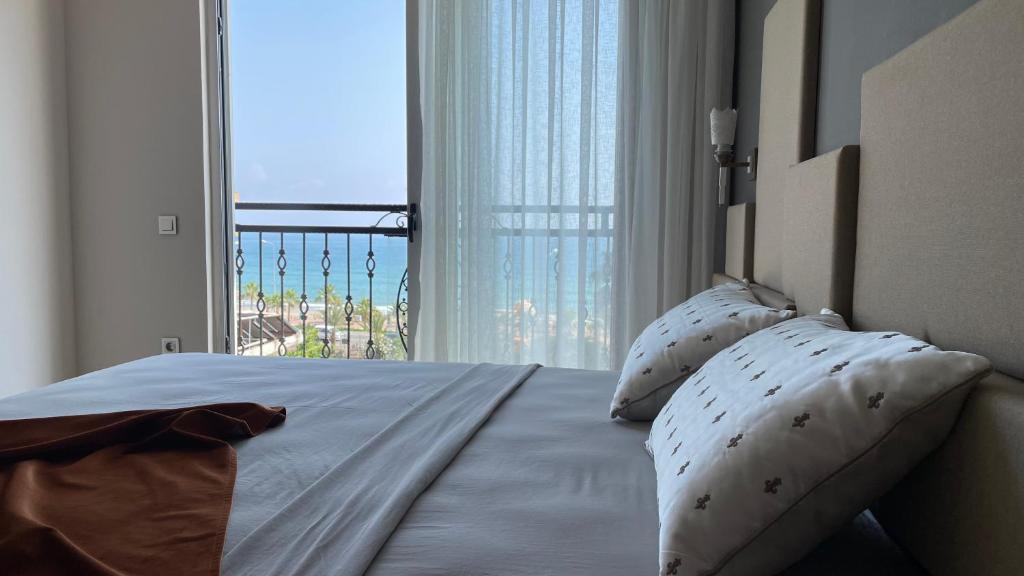 a bedroom with a bed with a view of the ocean at Green Garden City Luxury Apartments in Alanya