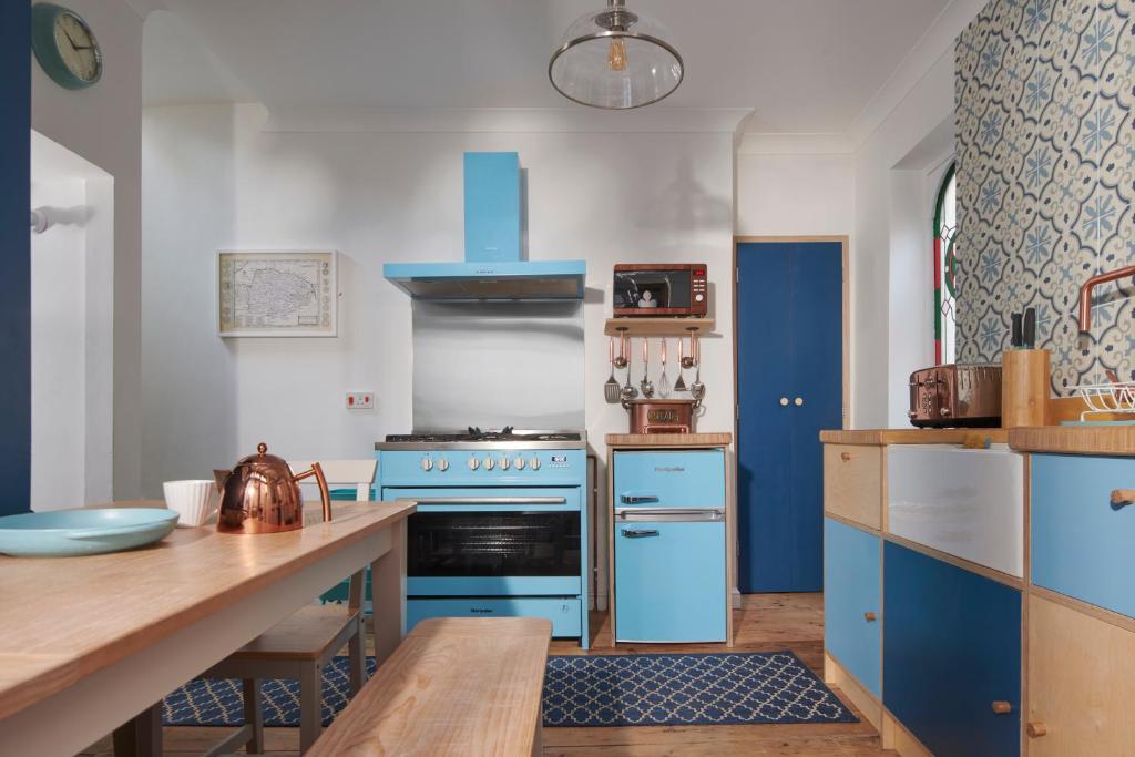 a kitchen with blue appliances and a wooden table at Refurbished Seaside Retreat in the Heart of Cromer in Cromer