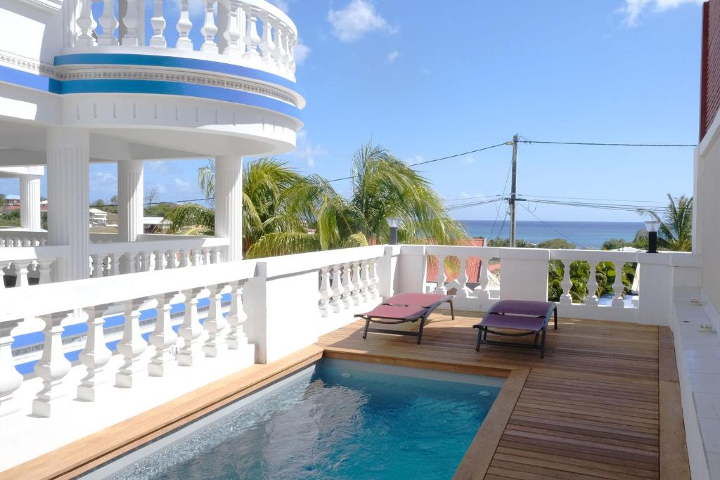 a balcony with two chairs and a swimming pool at Acajou in Sainte-Luce