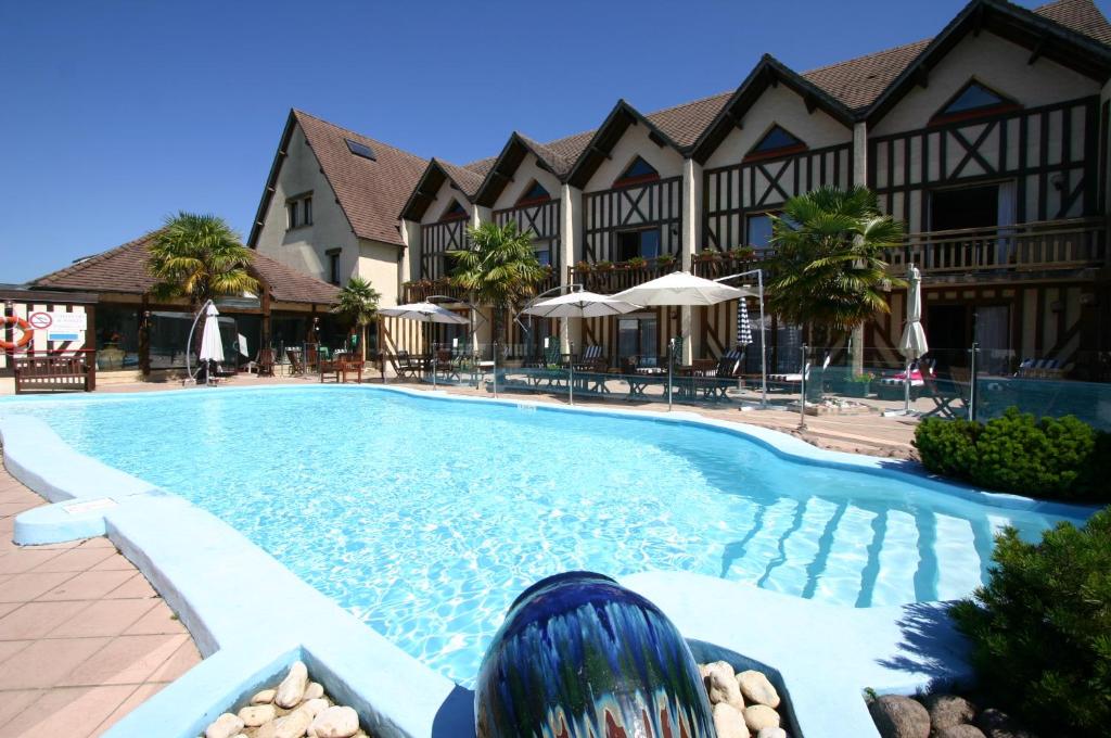 uma piscina em frente a um resort em Logis Le Clos Deauville Saint Gatien em Saint Gatien des Bois