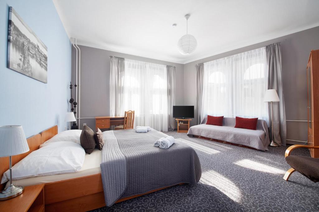 布拉格的住宿－貝爾城酒店，一间卧室配有一张大床和一张沙发