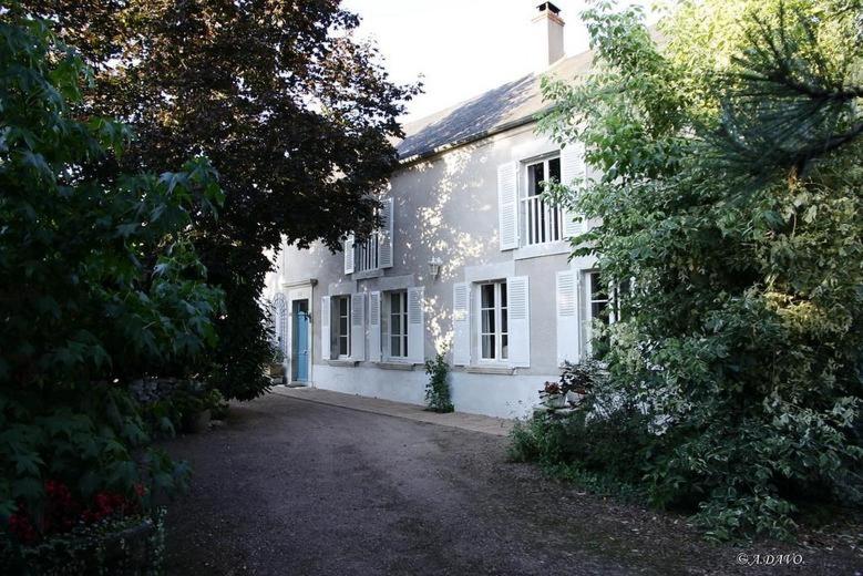Saint-Andelain的住宿－La Belle des Champs，前面有车道的白色房子