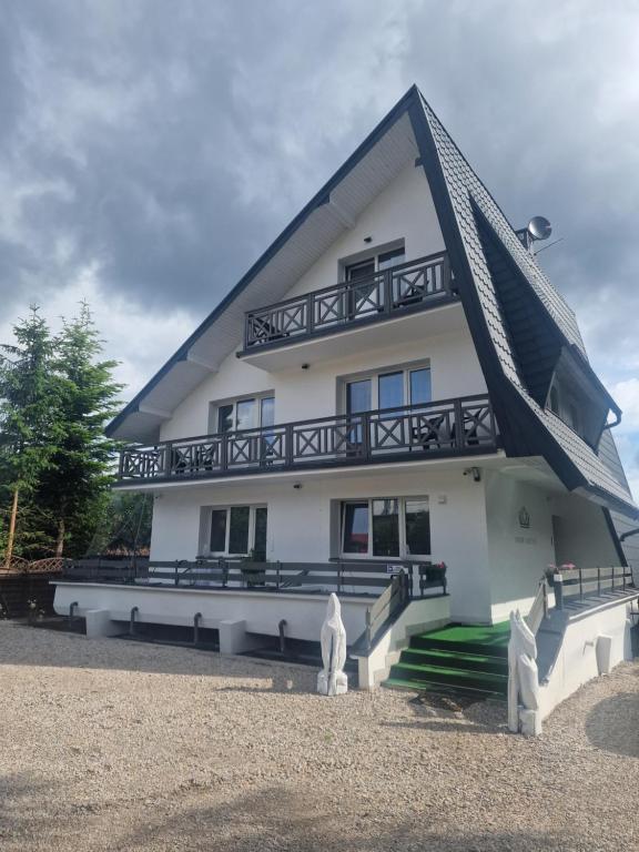 een groot wit huis met een gambrel dak bij Snow Queen in Szklarska Poręba