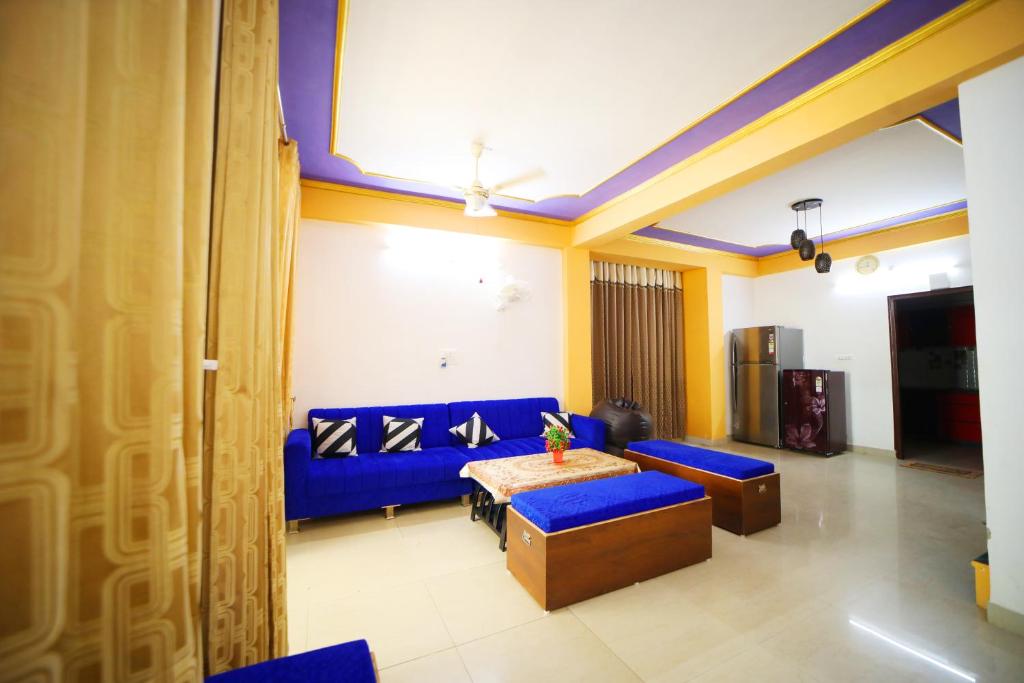 sala de estar con sofá azul y mesa en Boutique Indian Home Stay - Pandora Home Stay en Agra