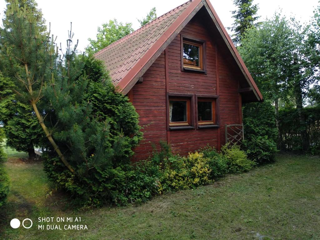 una casa roja con una ventana a un lado. en Domek letniskowy-Powidz ul.Topolowa en Powidz