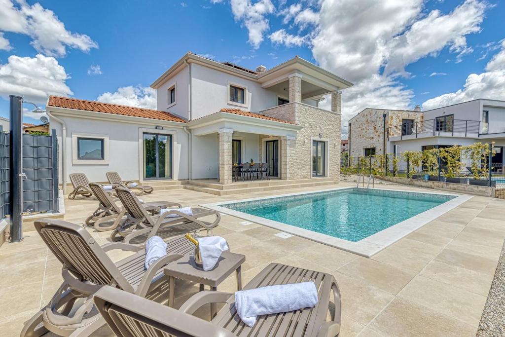 Willa z basenem i krzesłami w obiekcie Villa Istria Vabriga w mieście Vabriga