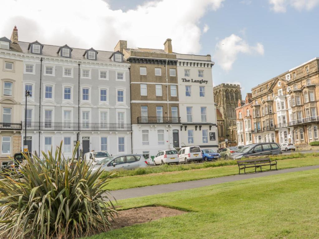 a bench in a park in front of buildings at Foxton Penthouse in Whitby