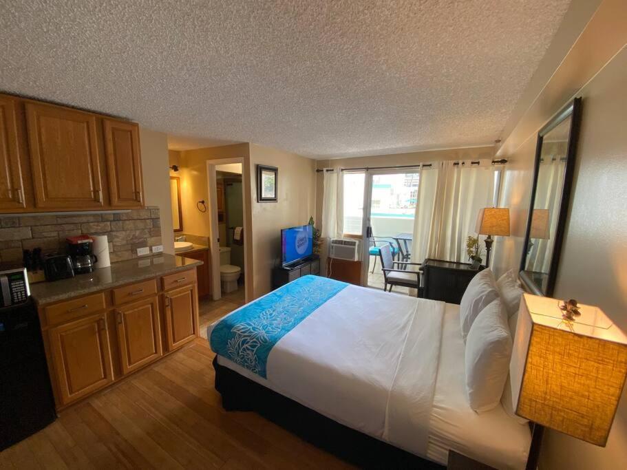 a hotel room with a large bed and a kitchen at Kuhio Village Towers 2 410a in Honolulu