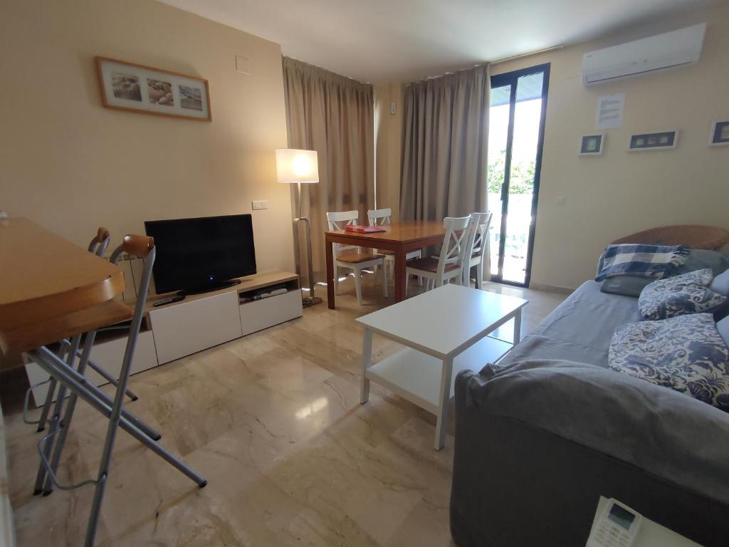 Sala de estar con cama y mesa con TV en Calafell Sant Antoni en Calafell