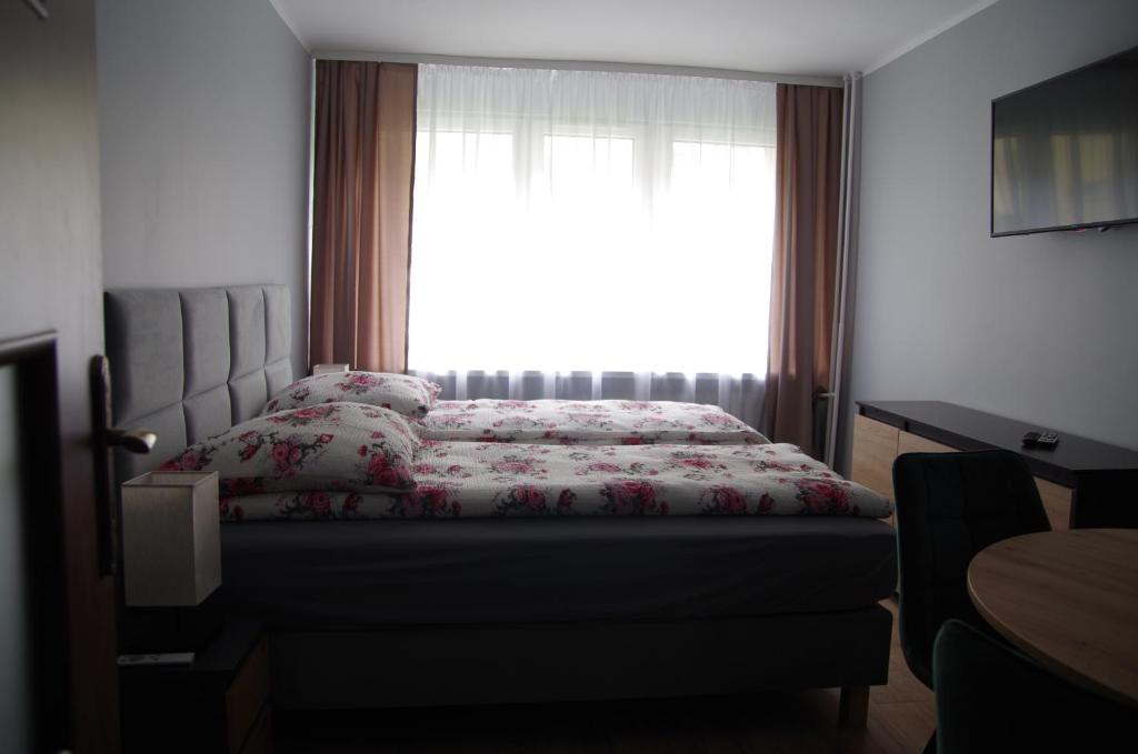 a bedroom with a bed and a window at Apartament Cesarski in Wałcz