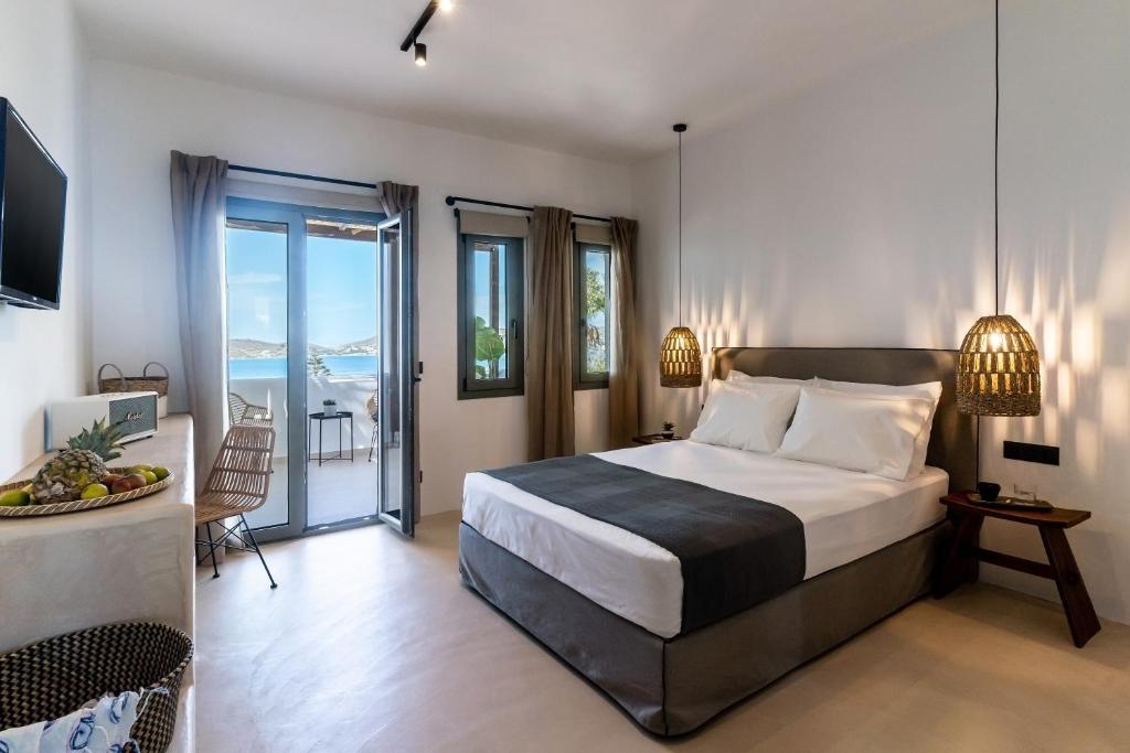 ein Schlafzimmer mit einem großen Bett und einem Balkon in der Unterkunft PAREA Paros - Adults Only in Kampos Paros