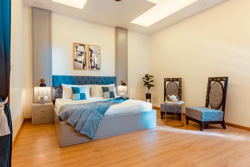 a bedroom with a king sized bed and a chair at Silver Leaf Apartments in Amritsar