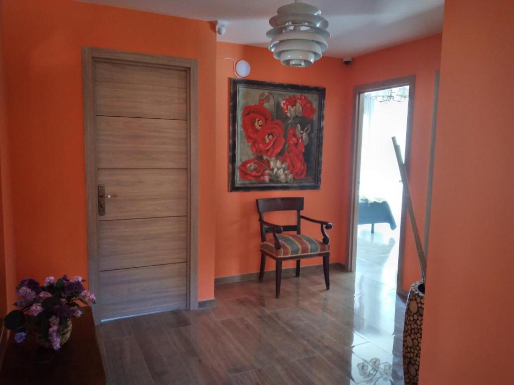 un corridoio con una stanza arancione con una porta e una sedia di Boutique Los Pinos a Denia