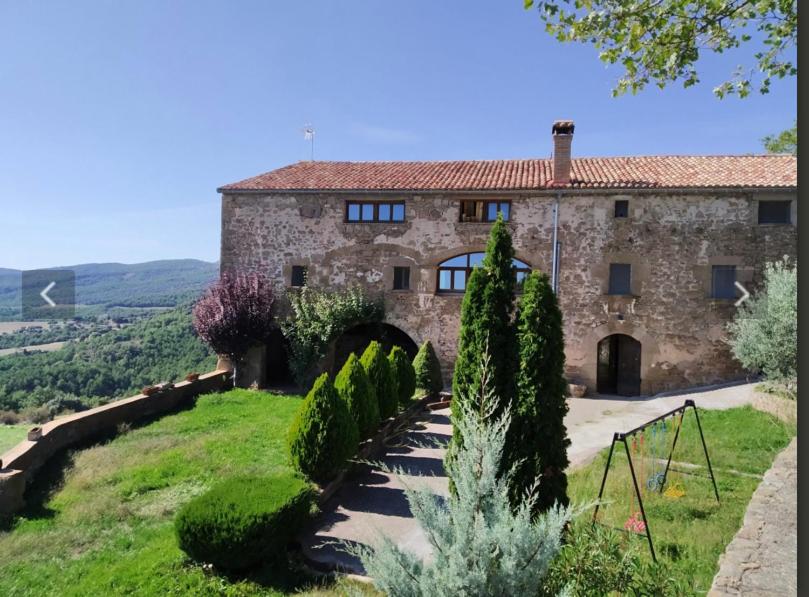 uma grande casa de pedra com um jardim em frente em Angrill em Lladurs