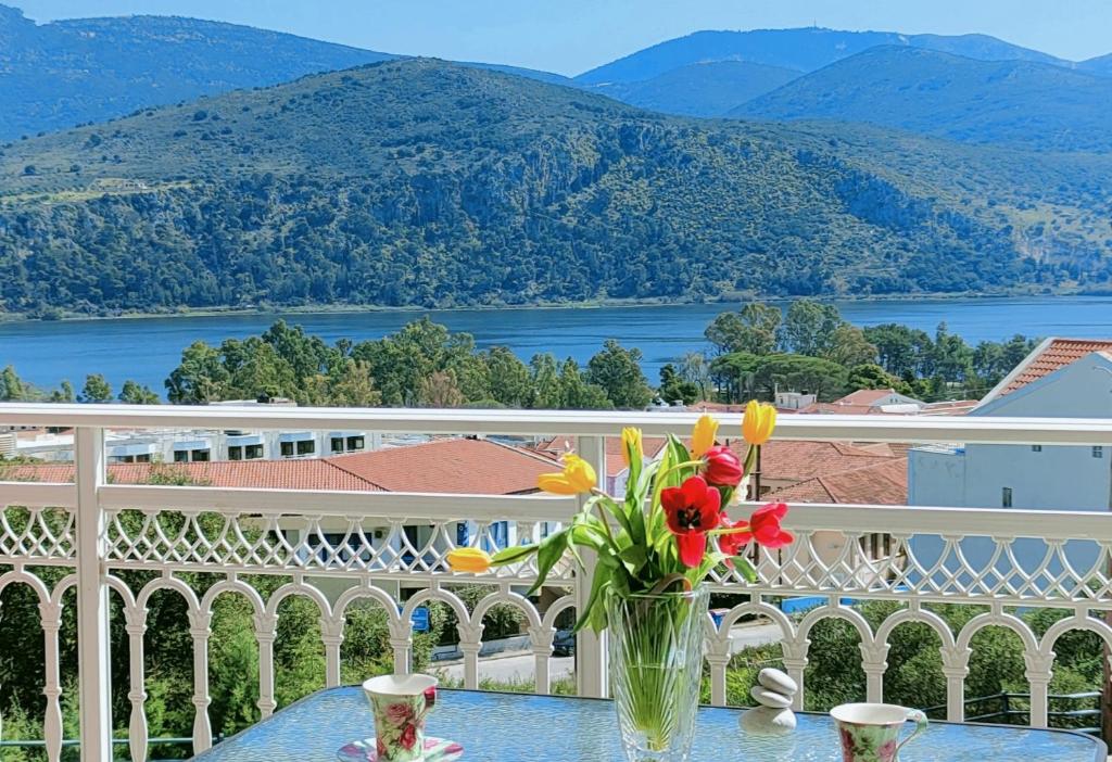 a vase of flowers sitting on a table on a balcony at Blue Lagoon Luxury Apartment A2 in Argostoli