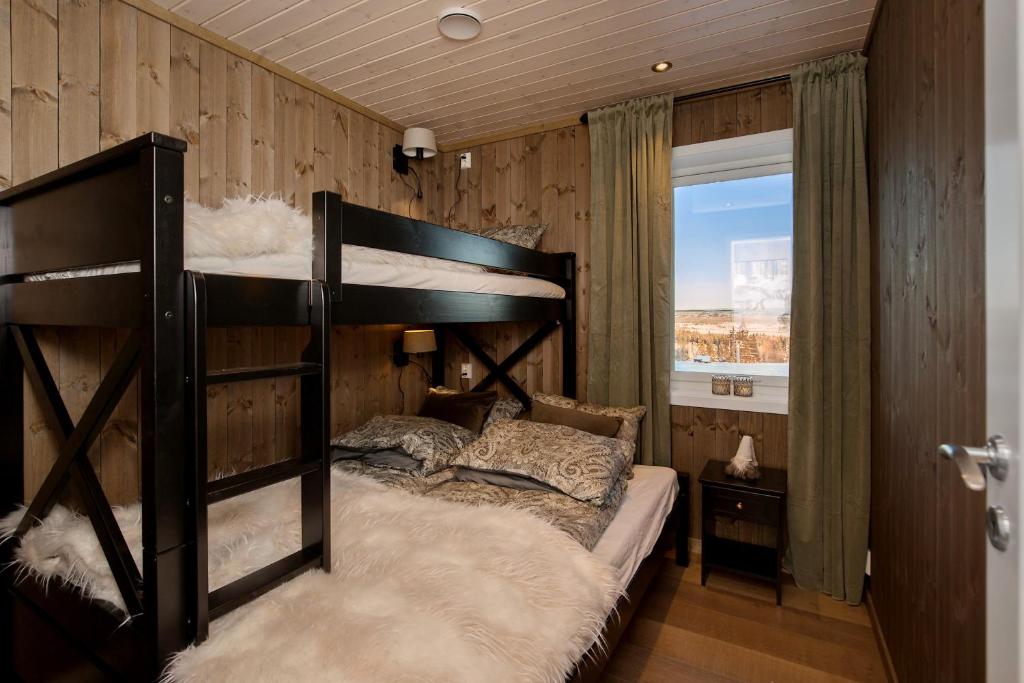 a bedroom with a bunk bed and a window at Golsfjellet - Bualie, milevis med sykkelveier, fiske og vannaktivitet, ski inn/ut til alpinanlegg og langrennsløyper. in Gol