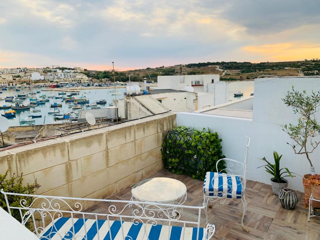 a balcony with chairs and a view of a harbor at Anthony's Sea Stay in Marsaxlokk