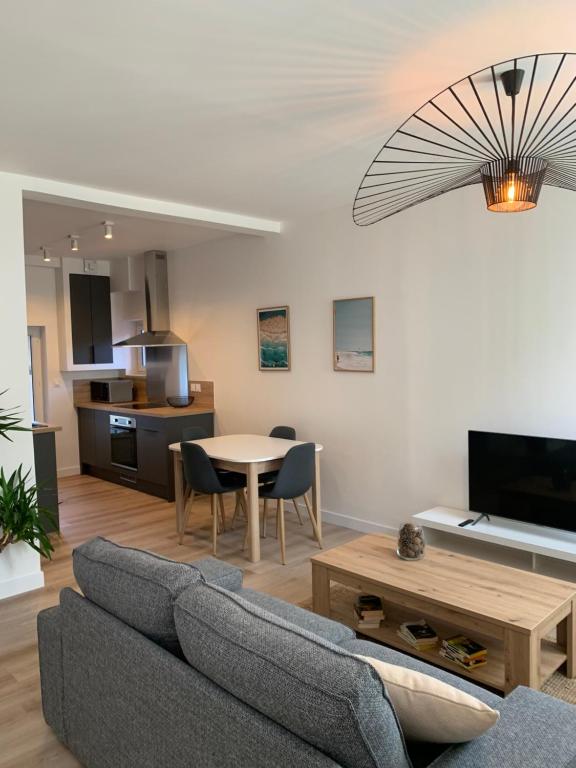 烏爾加特的住宿－L'Air de la Mer, 2 chambres, 50m plage, parking，客厅配有沙发和桌子