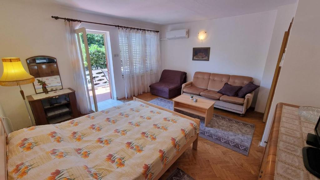 a living room with a bed and a couch at Apartment Cuhas with Terrace in Baška