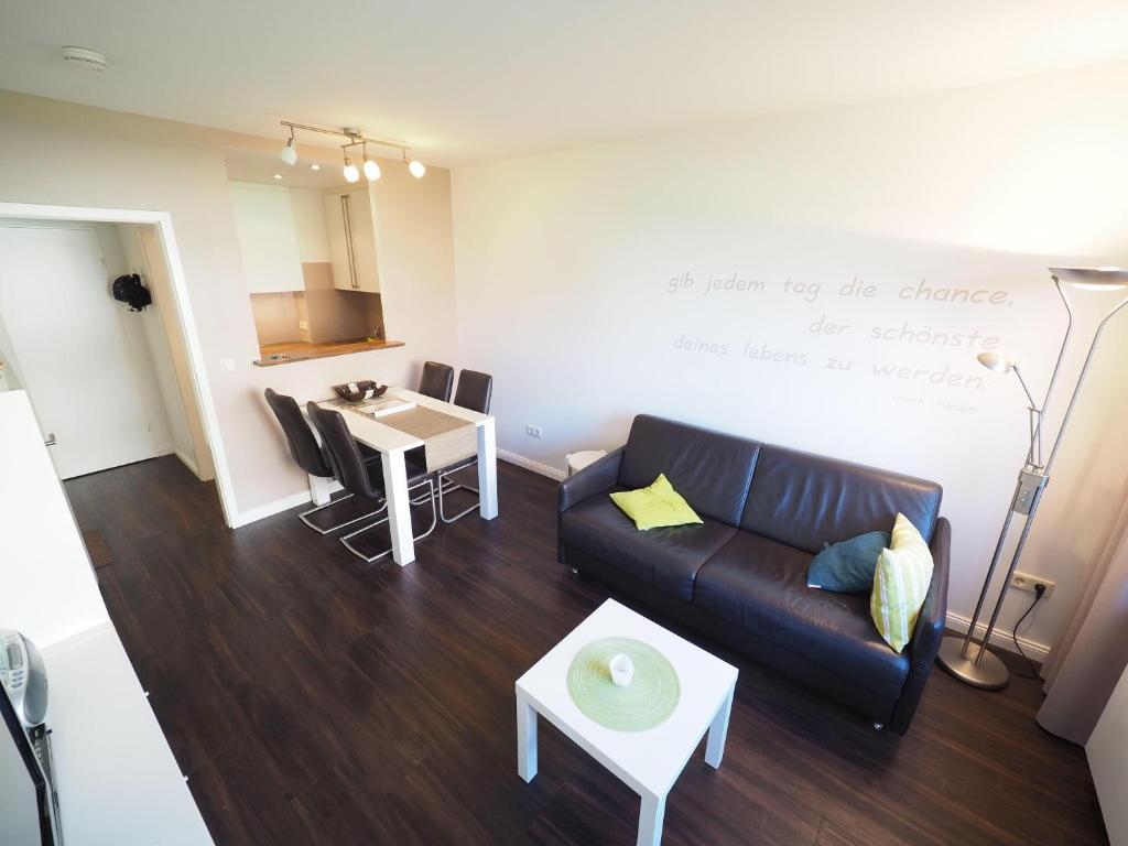 - un salon avec un canapé et une table dans l'établissement Appartement-173, à Westerland