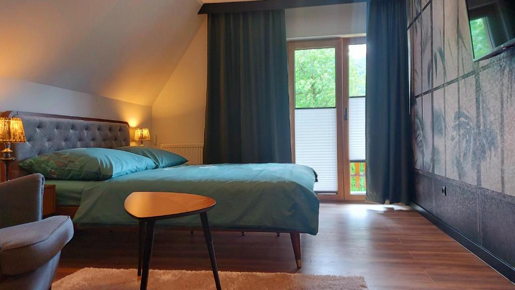 une chambre avec un lit, une chaise et une fenêtre dans l'établissement Willa Pod Reglami, à Zakopane