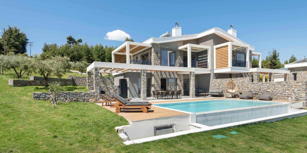 ein Haus mit einem Swimmingpool davor in der Unterkunft Koni Villas Agia Paraskevi by Halkidiki Villas in Agia Paraskevi