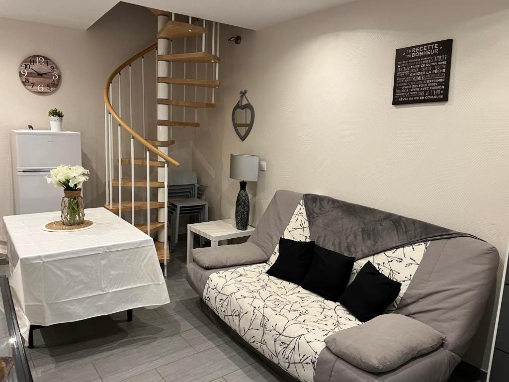 sala de estar con sofá y escalera en Dieppe duplex cosy en hyper centre, en Dieppe