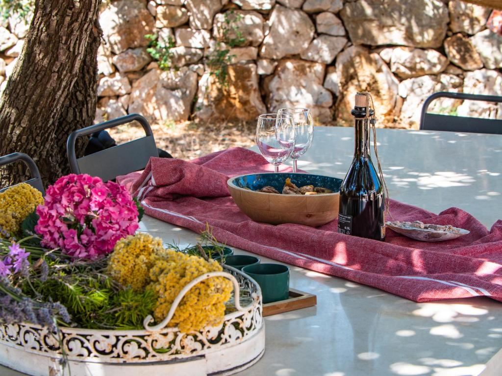 stół z butelką wina i kwiatami w obiekcie Hvar Cricket House Pakleni island w Hvarze