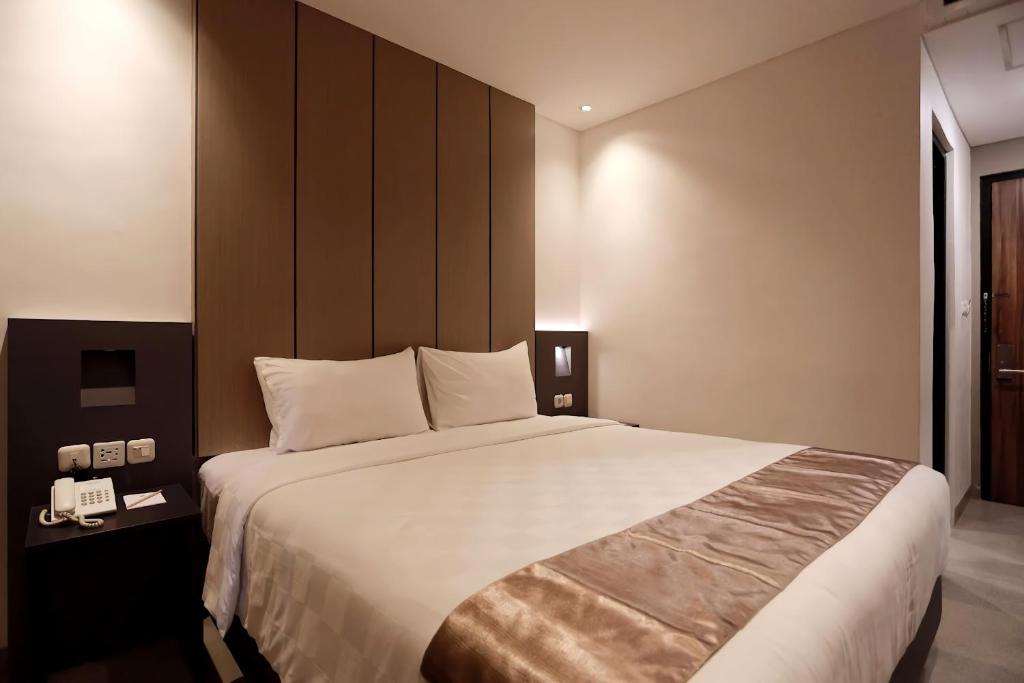 Postel nebo postele na pokoji v ubytování Hayo Hotel Palembang