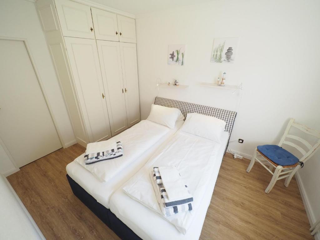 ein Wohnzimmer mit einer weißen Couch und einem Stuhl in der Unterkunft Appartement 36 in Westerland