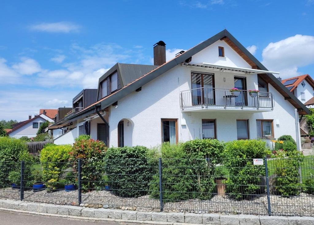 a white house with a fence in front of it at Ferienwohnung Bart in Friedrichshafen