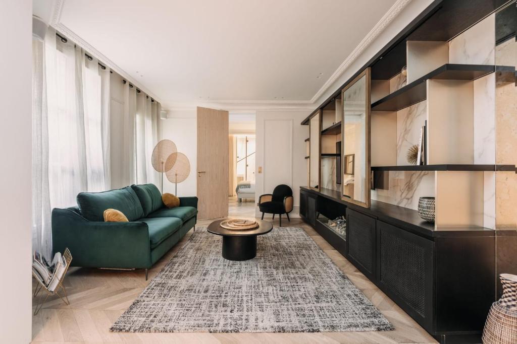 - un salon avec un canapé vert et une table dans l'établissement HIGHSTAY - Luxury Serviced Apartments - Tuileries Garden, à Paris