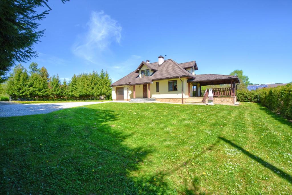 a house on a grassy field with a house at Bereszczańskie Sioło in Berezka