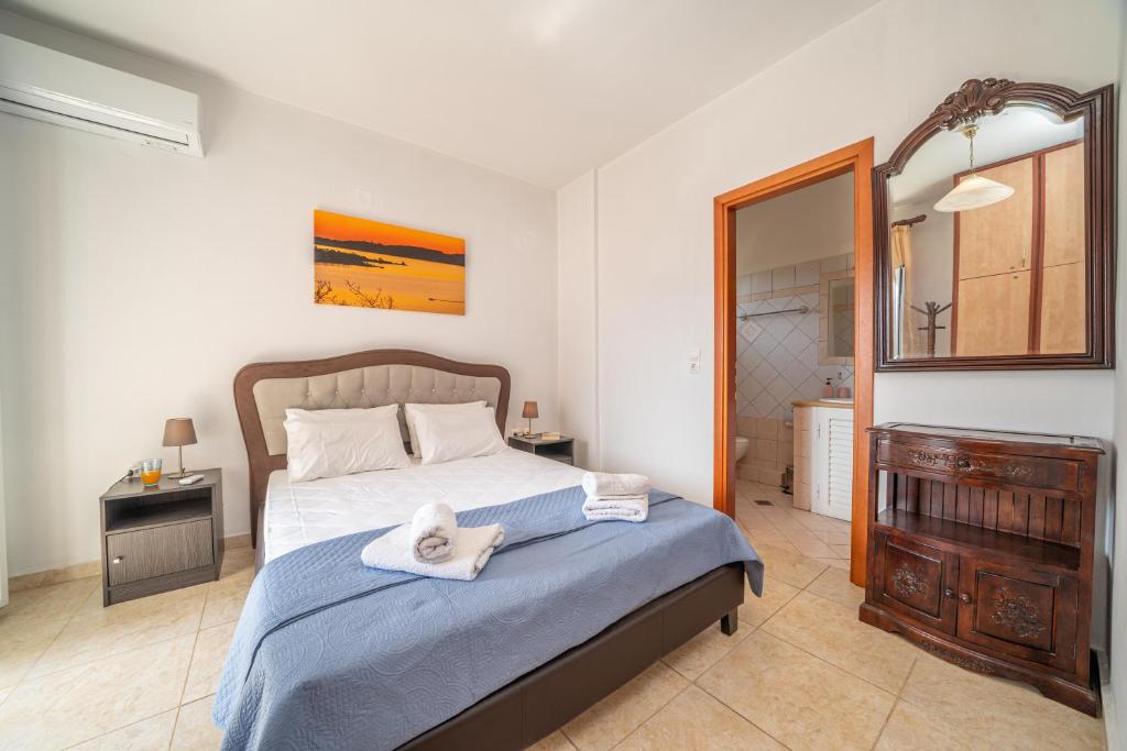 a bedroom with a large bed and a mirror at Eleonas Apartments in Pouláta