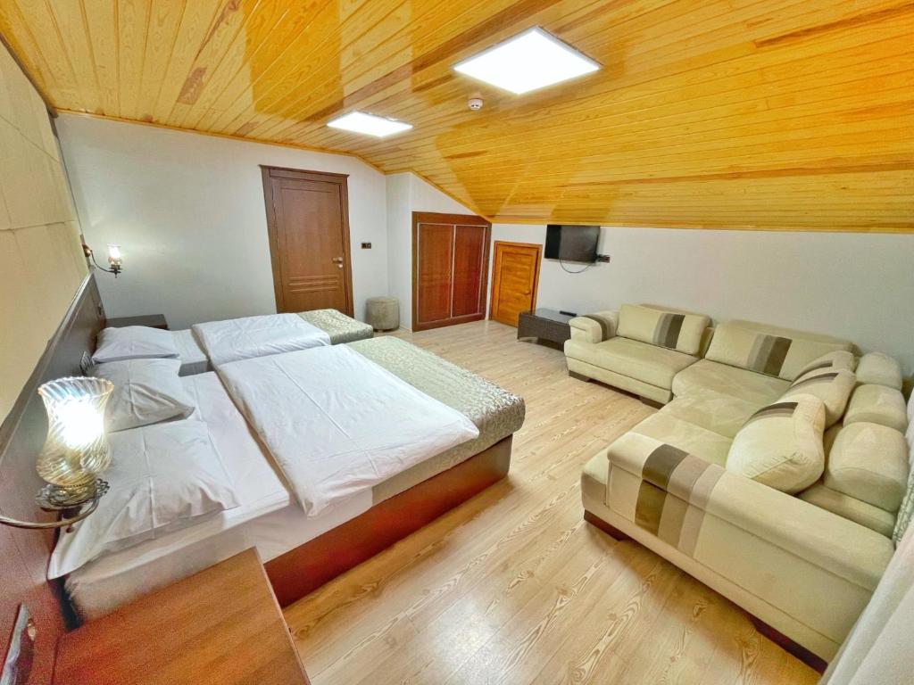 a large bedroom with a large bed and a couch at My Home Uzungöl in Uzungol