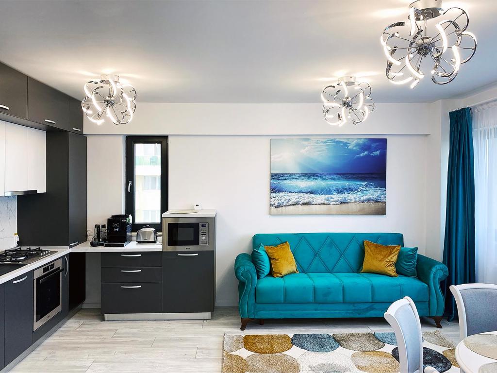 a living room with a blue couch in a kitchen at Ada Luxury Apartments 43 in Mamaia