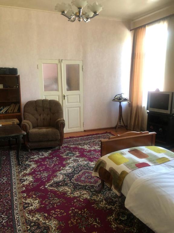 a bedroom with a bed and a couch and a chair at L&A Guest House in Goris