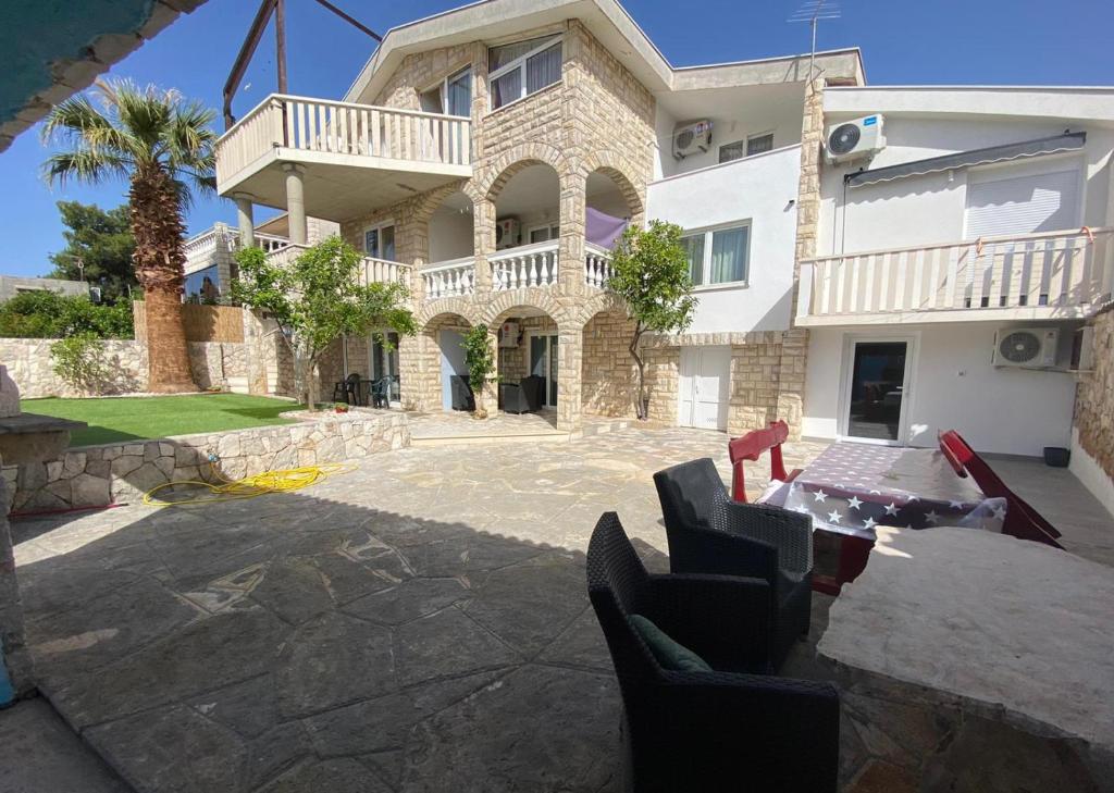 una casa con una mesa y sillas frente a ella en Apartments Kafadar, en Trogir