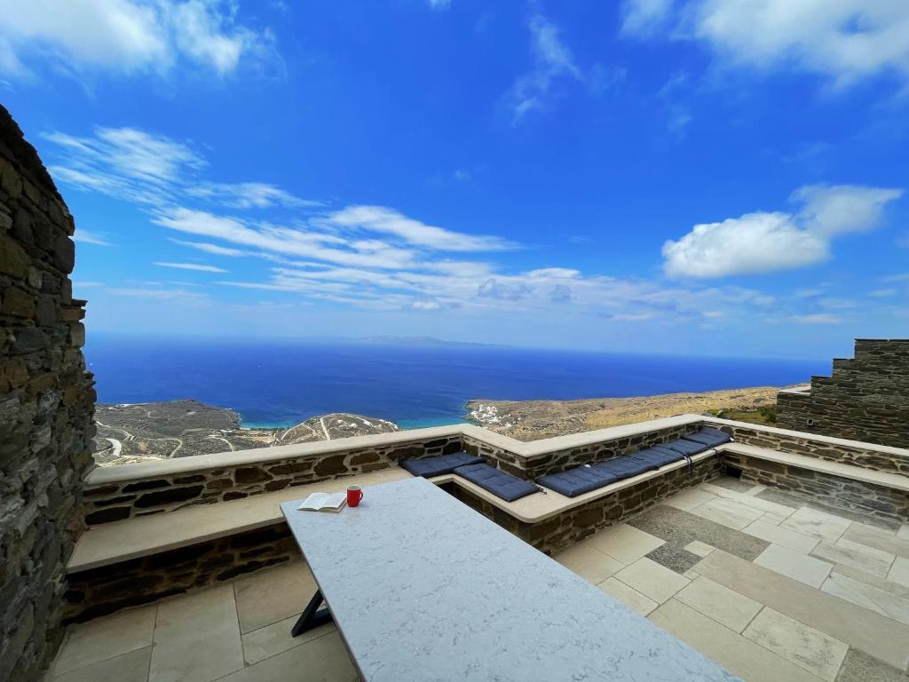 a table on a patio with a view of the ocean at Dionysos Sea and Stone Luxury Villa in Kardiani