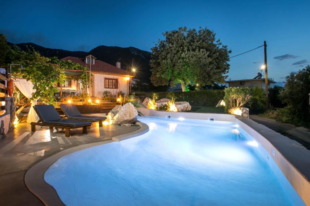 a swimming pool in a backyard at night at Old Nest House in Sálakos