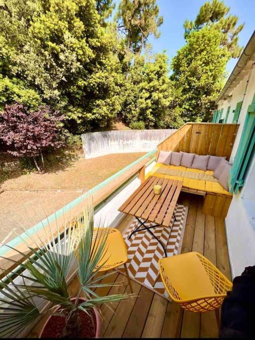 une terrasse avec deux chaises, une table et un banc dans l'établissement Front de mer Rivedoux-Plage - Terrasse Extérieur - Parking, à Rivedoux-Plage