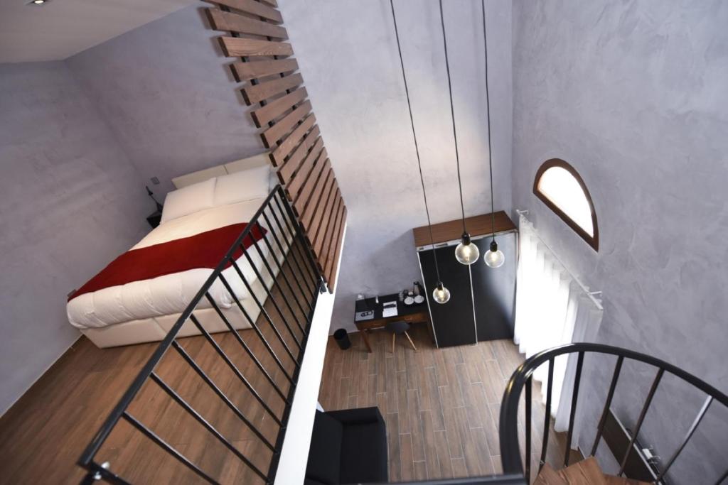 a room with a bed and a spiral staircase at Quaint Boutique Hotel Nadur in Nadur