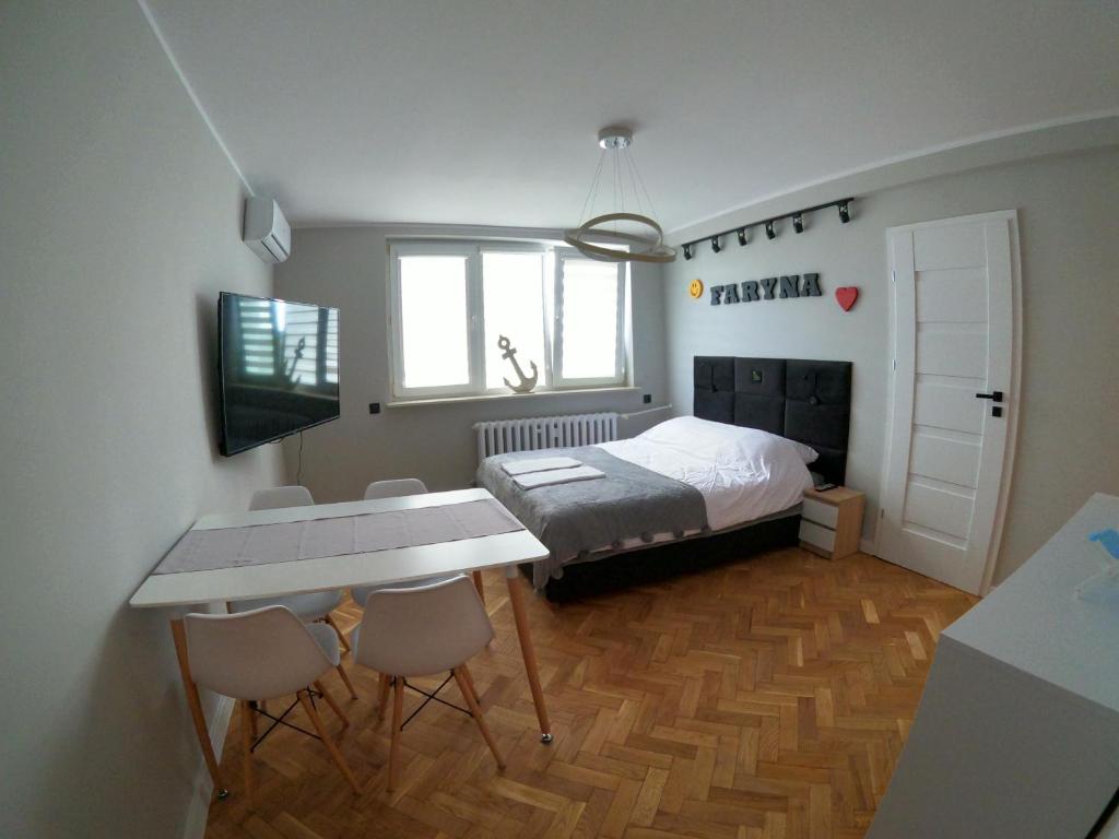 um quarto com uma cama, uma mesa e cadeiras em Faryna Apartament em Ruciane-Nida