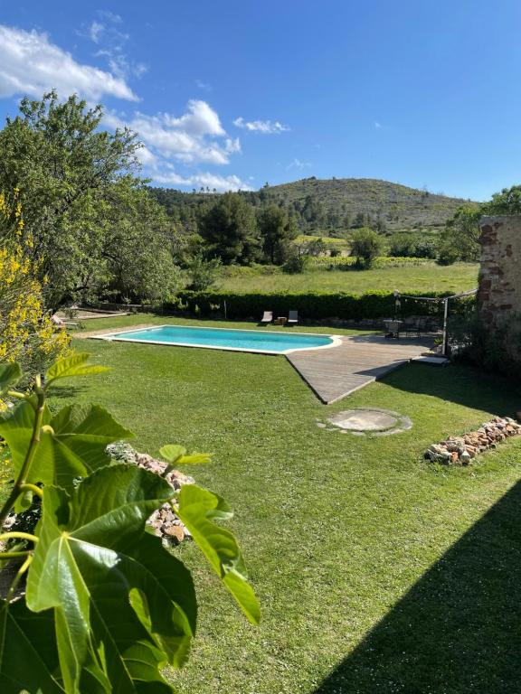 uma piscina num quintal com um relvado verde em Monte Vinea em Montouliers