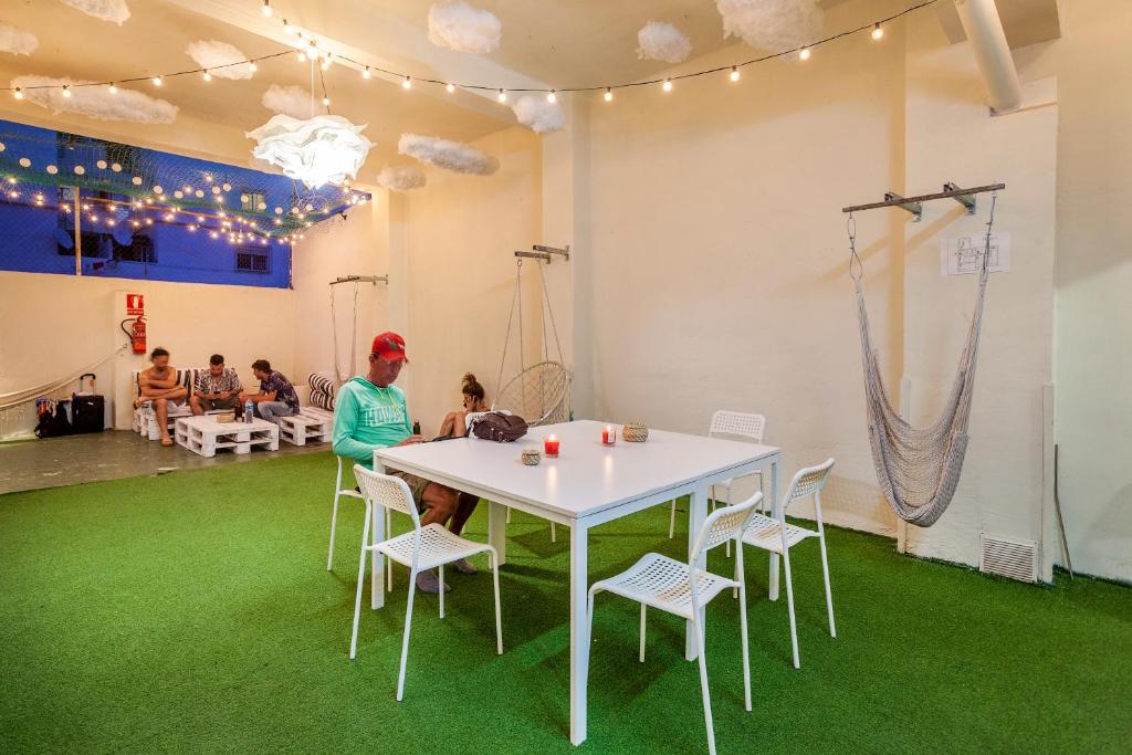 una persona sentada en una mesa en una habitación con alfombra verde en Coworking Balance en Valencia