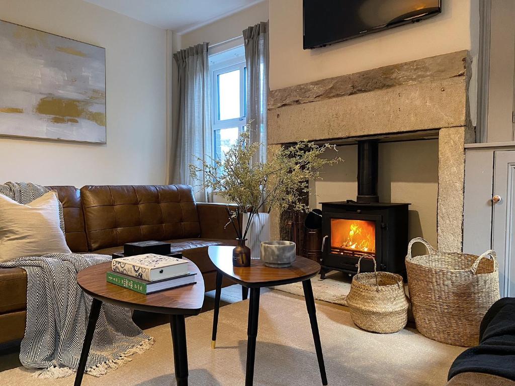 a living room with a couch and a fireplace at Beautiful & cosy 4 bedroom home in Todmorden
