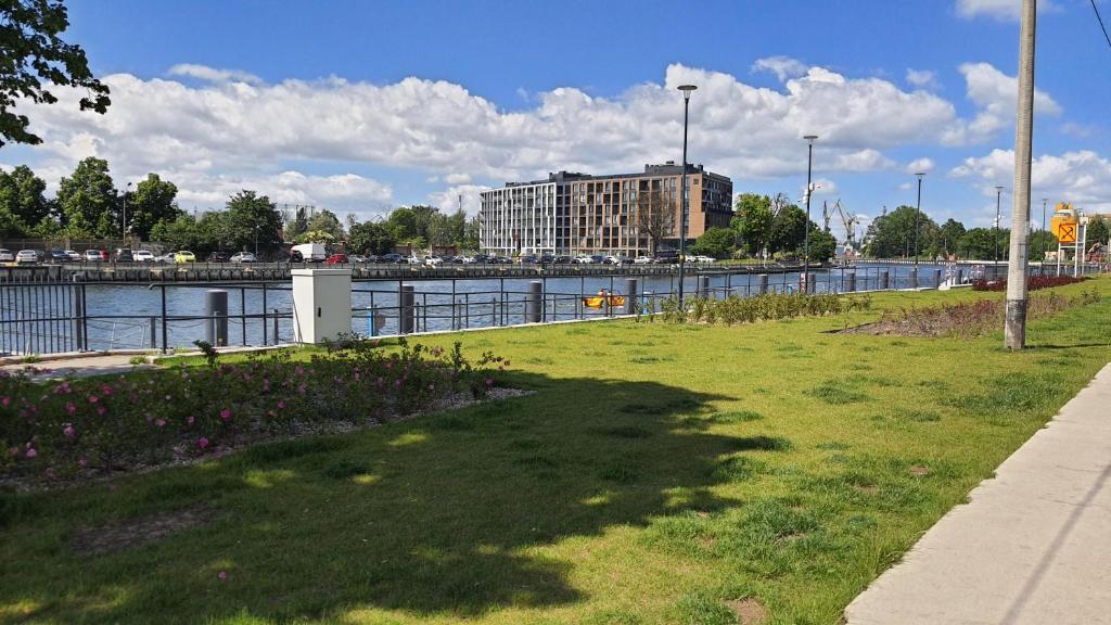 a grassy field next to a body of water at Old Town Nadmotławie - Sauna & Gym I 10min deptak in Gdańsk