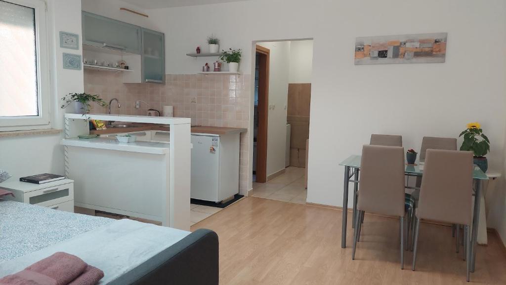 eine Küche und ein Wohnzimmer mit einem Tisch und Stühlen in der Unterkunft Studio 7even Ground Floor in Pula