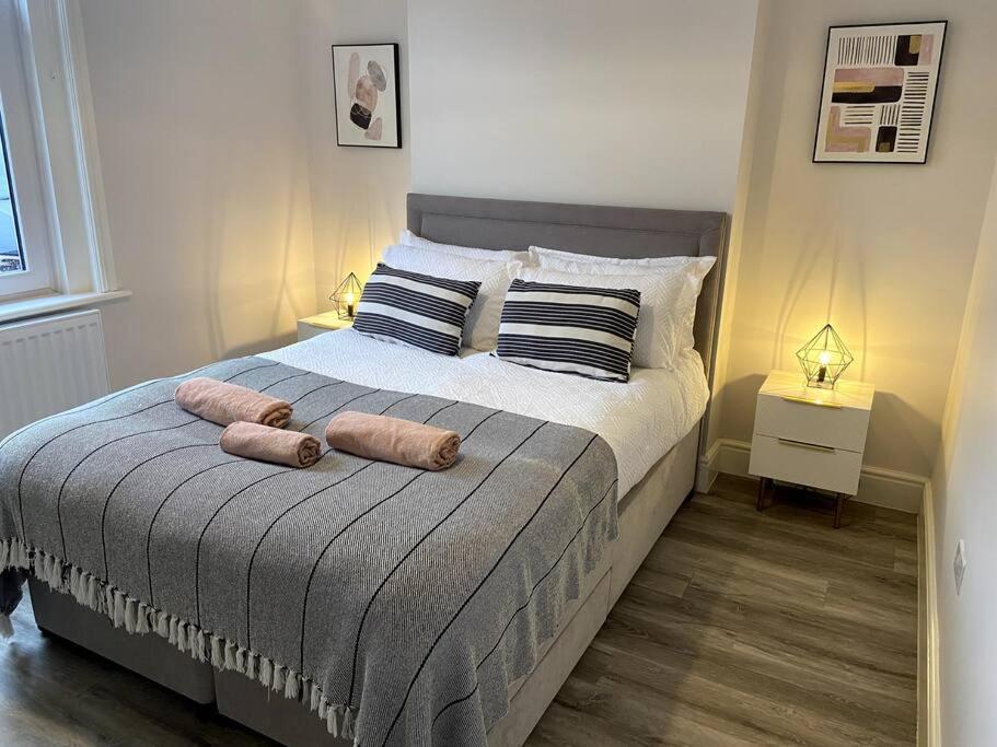 een slaapkamer met een bed met 2 kussens erop bij Modern Ground Floor Garden Apartment With Parking in South Hayling
