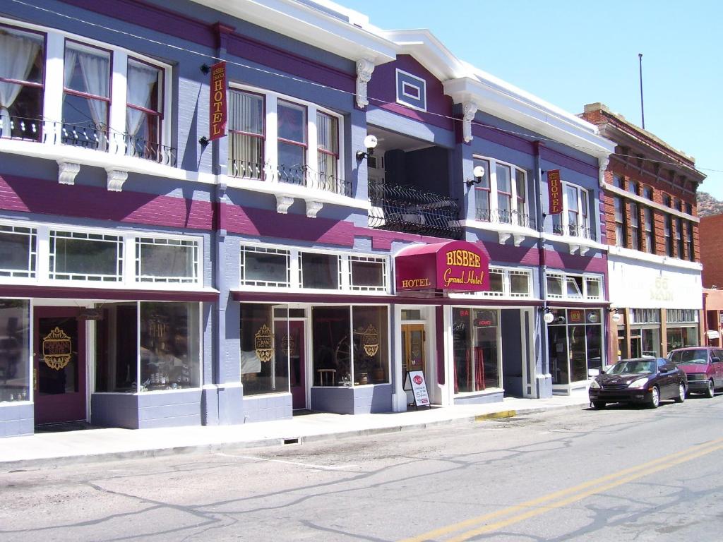 un edificio púrpura en una calle con coches aparcados delante en Bisbee Grand Hotel, en Bisbee
